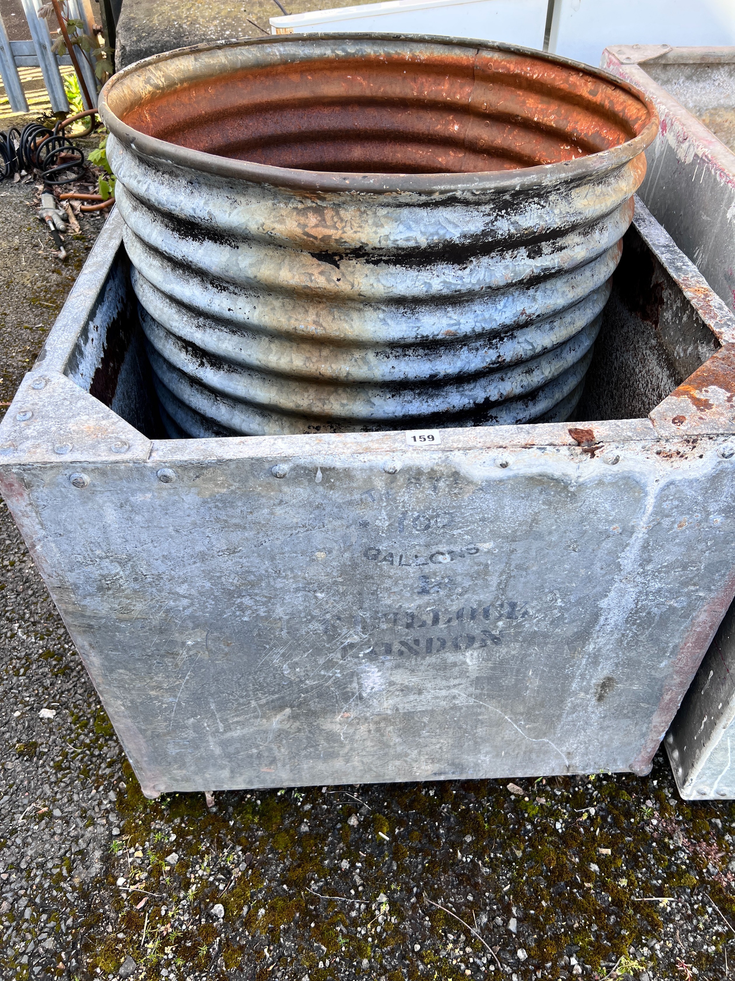 A large rectangular galvanised tank, width 90cm, depth 76cm, height 64cm together with a circular galvanised tank *Please note the sale commences at 9am.